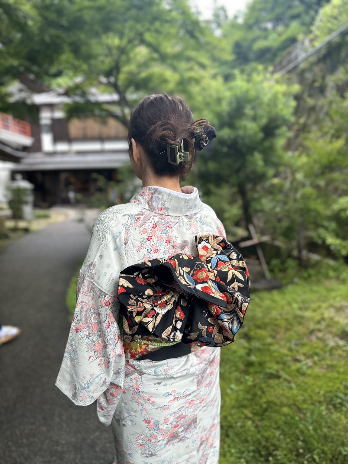 お稽古ジャパンで着物をまとい庭を歩く女性の後ろ姿