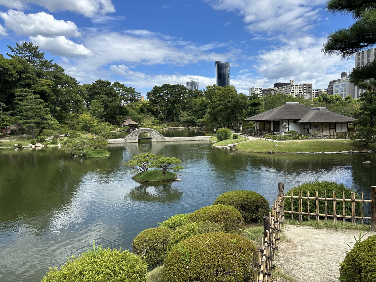 青空の下に池と跨虹橋が広がる縮景園の庭園風景